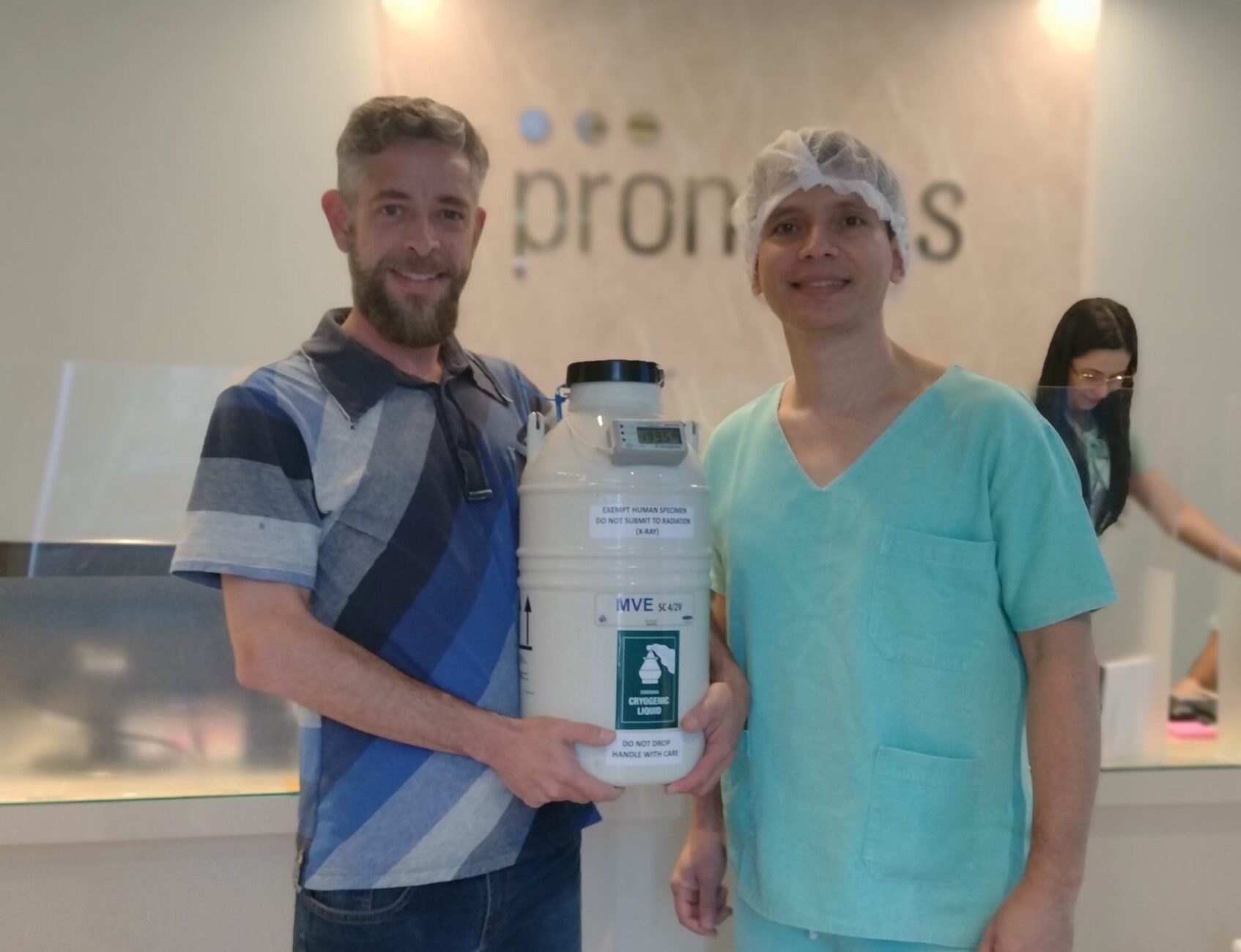 Courier delivering a dewar to a health worker of a fertility clinic.