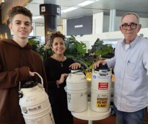 Three Mondo IVF international couriers in Colombia holding cryogenic dry shippers for reproductive material transport.