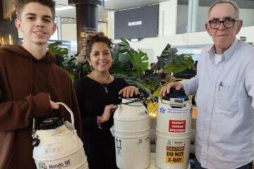 Three Mondo IVF international couriers in Colombia holding cryogenic dry shippers for reproductive material transport.